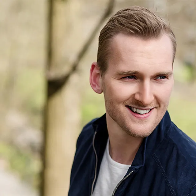 Bilde av smilende mann utendørs.
