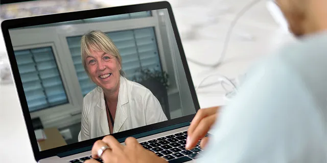 En person deltar i en digital videokonsultasjon med hudlege gjennom Askin.